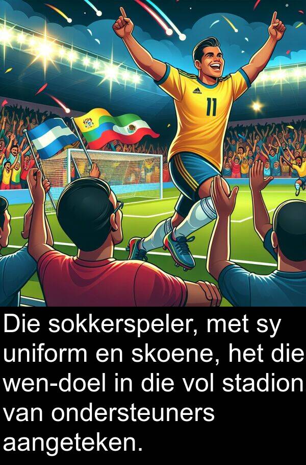 aangeteken: Die sokkerspeler, met sy uniform en skoene, het die wen-doel in die vol stadion van ondersteuners aangeteken.