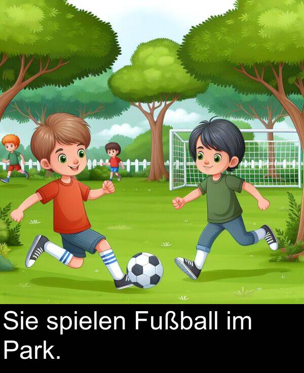 Fußball: Sie spielen Fußball im Park.