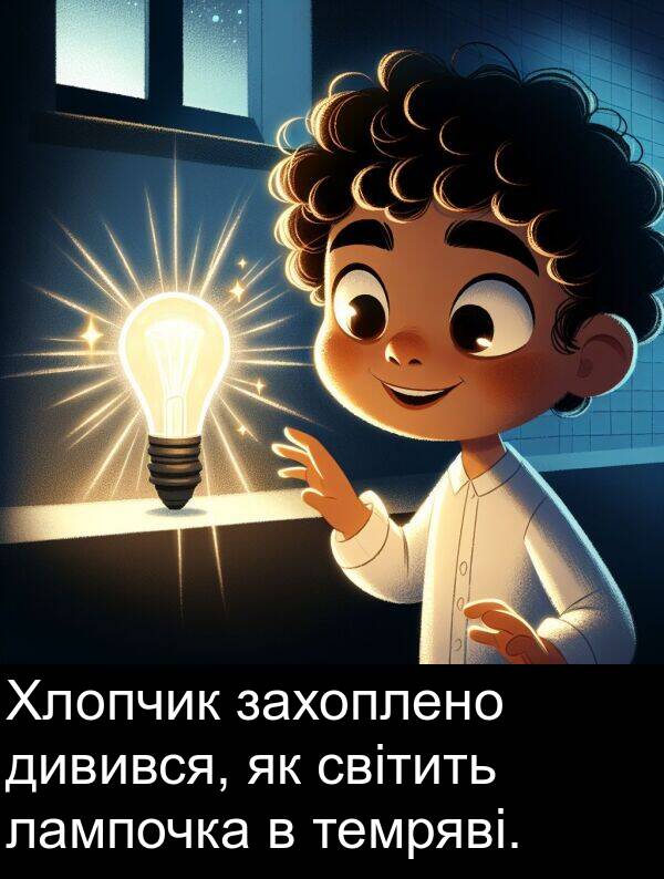 дивився: Хлопчик захоплено дивився, як світить лампочка в темряві.